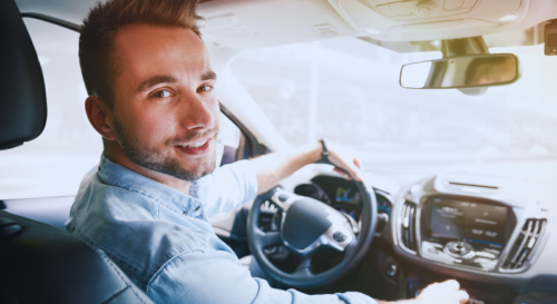 Junger Mann am Lenkrad visualisiert Steueränderungsgesetz 2025 Erhöhung Entfernungspauschale