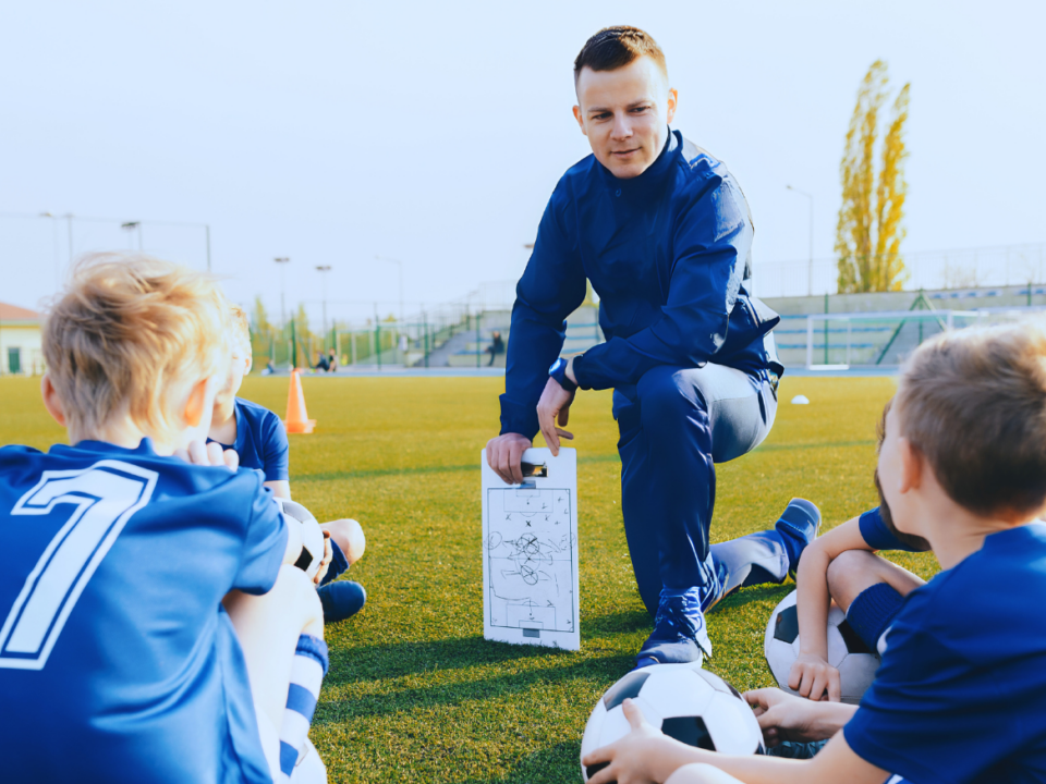 Fußballtrainer erklärt Kindern die Spielregeln visualisierend für: Übungsleiter- und Ehrenamtspauschale: Spielregeln für geringfügig Beschäftigte