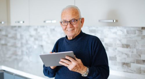 Älterer Mann mit Tablet in der Hand symbolisierent für Aktivrente